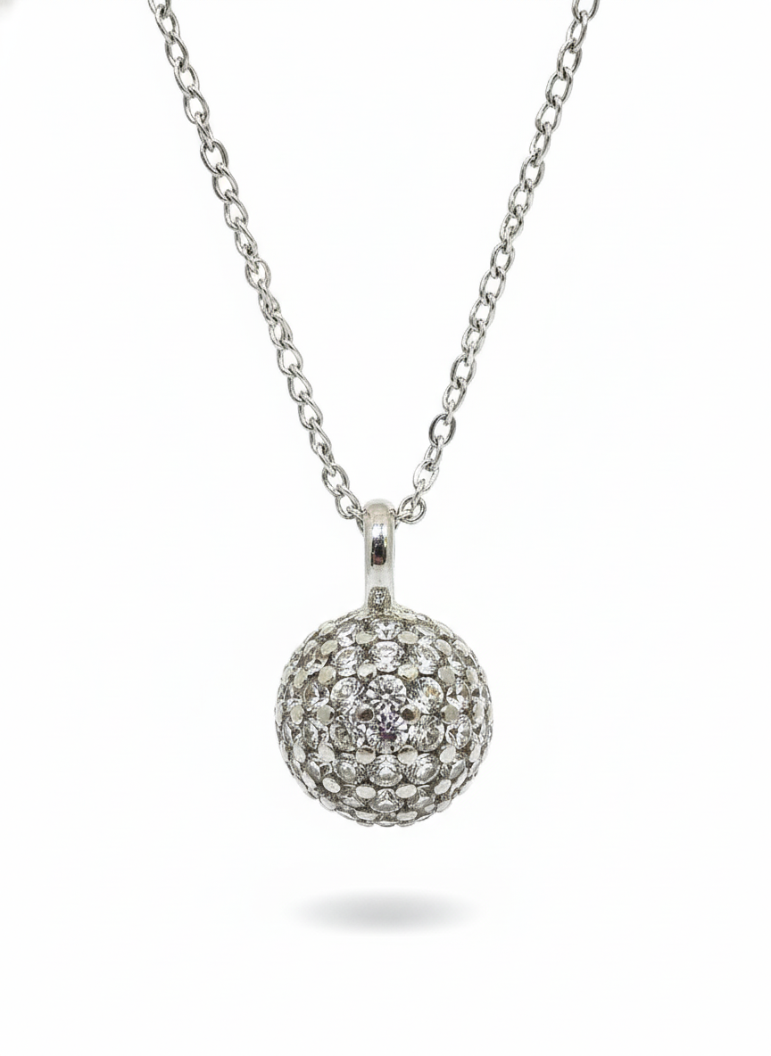 Silver necklace with a round, beaded pendant on a white background